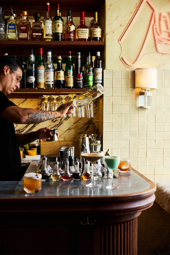 Bartendern på Bistro Marie häller upp en cocktail bakom bardisken