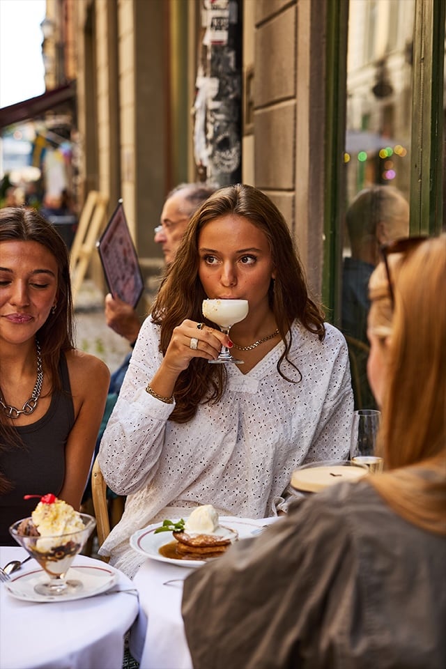 Gäster äter och dricker vin på uteserveringen utanför Bistro Marie i Gamla stan
