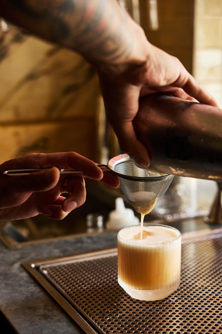 Närbild på en cocktail som silas upp i glas i Bistro Maries bar.