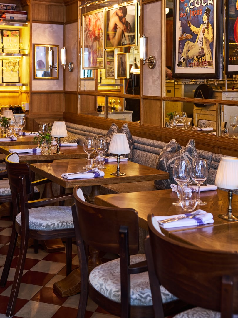 Matsalen på Bistro Marie med rutigt golv, träbord och varm belysning